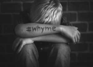 boy-with-hashtag-why-me-written-on-his-arm-300x216