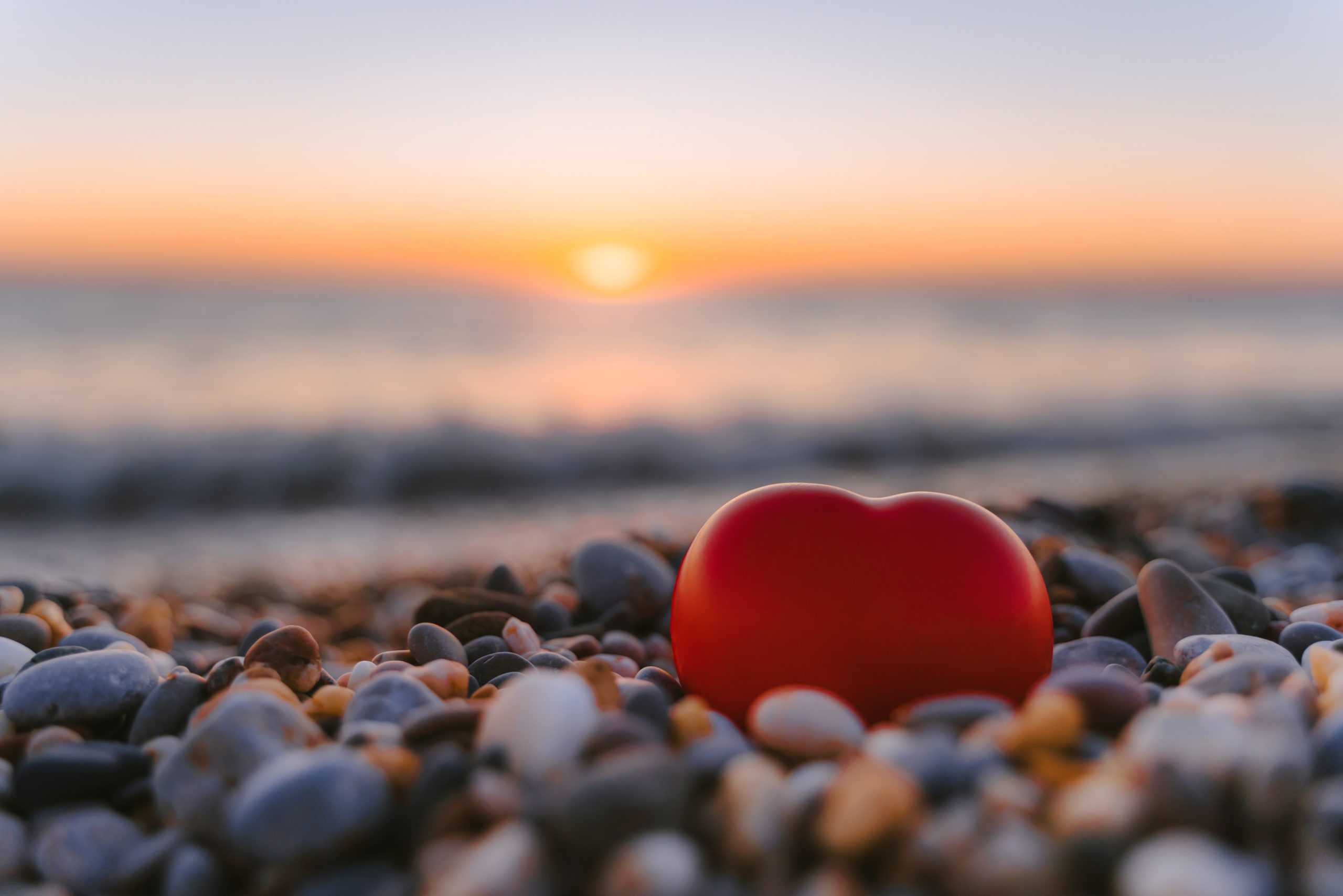 beautiful-pebbles-red-heart-quiet-calm-beach-sunset-concept-serenity-scaled